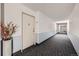 A carpeted hallway is shown with the front door visible, painted in neutral colors, with decor for a welcoming entrance at 14390 E Marina Dr # 403, Aurora, CO 80014