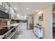 Modern kitchen features stainless steel appliances, white cabinetry, and stylish tile backsplash at 14390 E Marina Dr # 403, Aurora, CO 80014
