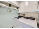 A laundry room equipped with modern washer and dryer, plus shelving for supplies, adds practicality to the living space at 14390 E Marina Dr # 403, Aurora, CO 80014