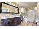 Bathroom with double sink vanity, large mirror, modern lighting, hardwood floors, and shower-tub combo at 1825 Spaulding Cir, Superior, CO 80027