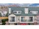 Multi-level townhouse featuring private balconies, a brick facade, and lush green landscaping with mountain views at 1825 Spaulding Cir, Superior, CO 80027