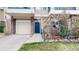 Townhouse exterior featuring a welcoming blue front door with a wreath, garage, and landscaped yard at 1825 Spaulding Cir, Superior, CO 80027