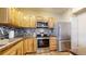 Bright kitchen featuring stainless steel appliances, natural wood cabinets, mosaic tile backsplash and granite countertops at 1825 Spaulding Cir, Superior, CO 80027
