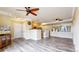 Open-concept living space with wood floors, a ceiling fan, and views into the kitchen and outdoor balcony at 1825 Spaulding Cir, Superior, CO 80027