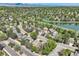 Picturesque aerial view highlights houses near a lake, tennis courts, and tree-lined streets with mountain views at 8820 W 80Th Dr, Arvada, CO 80005