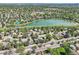 Scenic aerial view shows houses nestled in a lush neighborhood near a tranquil lake and a green field at 8820 W 80Th Dr, Arvada, CO 80005