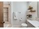 Bathroom featuring a tiled shower, modern shelves, toilet and single sink vanity at 8820 W 80Th Dr, Arvada, CO 80005