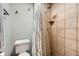 Bathroom featuring a shower with tile surround, toilet and chrome hardware at 8820 W 80Th Dr, Arvada, CO 80005