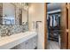 Bathroom vanity featuring framed mirrors, double sinks, chrome faucets, and storage at 8820 W 80Th Dr, Arvada, CO 80005