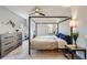 Bright bedroom featuring a four-poster bed frame, dresser and views to the exterior at 8820 W 80Th Dr, Arvada, CO 80005