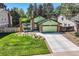 Inviting home exterior with lush lawn, mature trees, and a well-maintained driveway at 8820 W 80Th Dr, Arvada, CO 80005