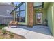 Inviting front porch with a bench, brick accents, and a stylish glass front door at 8820 W 80Th Dr, Arvada, CO 80005