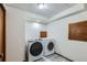Well-equipped laundry room with modern washer and dryer and neutral tile flooring at 8820 W 80Th Dr, Arvada, CO 80005