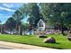 Community pool area featuring lounge chairs, umbrellas, and a building, all enclosed by a fence at 8820 W 80Th Dr, Arvada, CO 80005