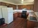 Kitchen with wood floors and cabinets, updated appliances, and a white refrigerator at 16032 E Floyd Ave, Aurora, CO 80013
