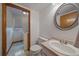 Bathroom featuring a light pink vanity, oval mirror, toilet, and access to the laundry room at 292 S Pembrook St, Castle Rock, CO 80104