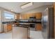 Kitchen with stainless steel appliances, a center island, and black countertops with natural wood cabinets at 292 S Pembrook St, Castle Rock, CO 80104
