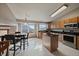 Bright kitchen featuring an island with black countertop, stainless steel appliances, and tile flooring at 292 S Pembrook St, Castle Rock, CO 80104