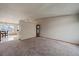A spacious, carpeted living room is bright with natural light, featuring a dividing wall to adjacent room at 292 S Pembrook St, Castle Rock, CO 80104