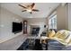 Cozy living room featuring a brick fireplace, ceiling fan, plush furnishings, and ample natural light at 292 S Pembrook St, Castle Rock, CO 80104