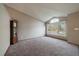 Large, carpeted living room featuring a large window, neutral colored walls, and a vaulted ceiling at 292 S Pembrook St, Castle Rock, CO 80104
