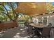 Spacious back deck shaded with large sun shade, seating area, bench, and table at 5060 W 71St Pl, Westminster, CO 80030