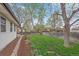 Expansive backyard with lush greenery, mature trees, and a charming garden bed at 5060 W 71St Pl, Westminster, CO 80030