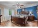 Main bedroom boasts a wooden bedframe, hardwood floors, and an accent wall at 5060 W 71St Pl, Westminster, CO 80030