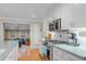 Modern kitchen featuring white cabinets, stainless steel appliances, and hardwood floors at 5060 W 71St Pl, Westminster, CO 80030