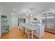 A kitchen featuring white cabinetry, a stainless steel refrigerator, and an island with pendant lighting at 5060 W 71St Pl, Westminster, CO 80030