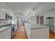 Bright kitchen boasts stainless steel appliances, a large island with pendant lights, and hardwood floors at 5060 W 71St Pl, Westminster, CO 80030