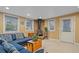 A living room showcases a blue couch, a wood burning stove, and neutral carpeting at 5060 W 71St Pl, Westminster, CO 80030