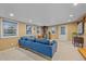 A living room featuring a blue couch, a wood-burning stove, and neutral carpeting at 5060 W 71St Pl, Westminster, CO 80030