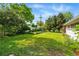 Expansive backyard with a lush green lawn, mature trees, and garden beds, providing a private and serene outdoor space at 1395 S Kendall St, Lakewood, CO 80232