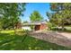 Spacious backyard features a hammock and a covered patio offering a relaxing outdoor retreat on a well-maintained lawn at 1395 S Kendall St, Lakewood, CO 80232