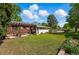 Well-maintained backyard showcases a covered patio with seating and a grill, surrounded by a lush green lawn and garden at 1395 S Kendall St, Lakewood, CO 80232