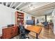 Finished basement features a spacious office area with wood desk, chair, and exposed ceiling at 1395 S Kendall St, Lakewood, CO 80232