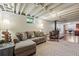 Finished basement featuring a cozy living area with wood burning stove, exposed ceiling, and office area at 1395 S Kendall St, Lakewood, CO 80232