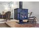 Close up of the wood burning stove featuring a brick base, iron casing, and wood storage at 1395 S Kendall St, Lakewood, CO 80232
