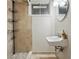 Modern bathroom with tiled shower, floating sink, and black storage shelves at 1395 S Kendall St, Lakewood, CO 80232