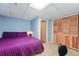 Cozy bedroom featuring neutral carpet, light blue walls, and a purple bedspread at 1395 S Kendall St, Lakewood, CO 80232
