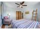 Neutral bedroom with hardwood floors and a ceiling fan features a chair, ladder, and closet at 1395 S Kendall St, Lakewood, CO 80232