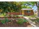 Charming brick home with a landscaped front yard, featuring a walkway leading to the front door and mature trees at 1395 S Kendall St, Lakewood, CO 80232
