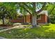 Charming brick home with mature trees and a well-manicured lawn, creating a welcoming curb appeal at 1395 S Kendall St, Lakewood, CO 80232