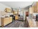Bright kitchen with stainless steel refrigerator, granite countertops, and wood cabinets, complemented by tile backsplash at 1395 S Kendall St, Lakewood, CO 80232