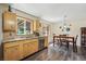 Well-lit kitchen with wood cabinets, granite countertops, and adjacent dining area at 1395 S Kendall St, Lakewood, CO 80232