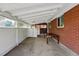 Covered patio area featuring a table, brick accents, and ample lighting at 1395 S Kendall St, Lakewood, CO 80232