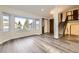 Bright living room featuring new light wood flooring, a large bay window, and a staircase at 11892 Vallejo St, Denver, CO 80234