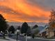 A suburban street during a vibrant sunset, with mountains in the distance at 11892 Vallejo St, Denver, CO 80234