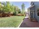 Lush backyard with fence, trees, and walkway to back door with exterior access at 13777 W Amherst Way, Lakewood, CO 80228